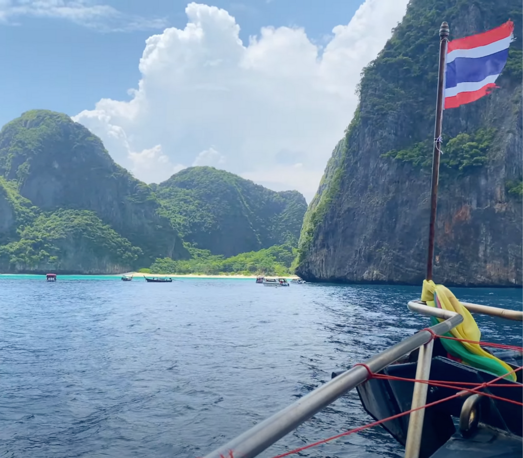 Vue imprenable des formations rocheuses calcaires émergentes de l'eau turquoise, typiques de l'approche de Koh Phi Phi en ferry. Le ciel bleu et les eaux cristallines ajoutent à la beauté naturelle de ce paysage emblématique de la Thaïlande.