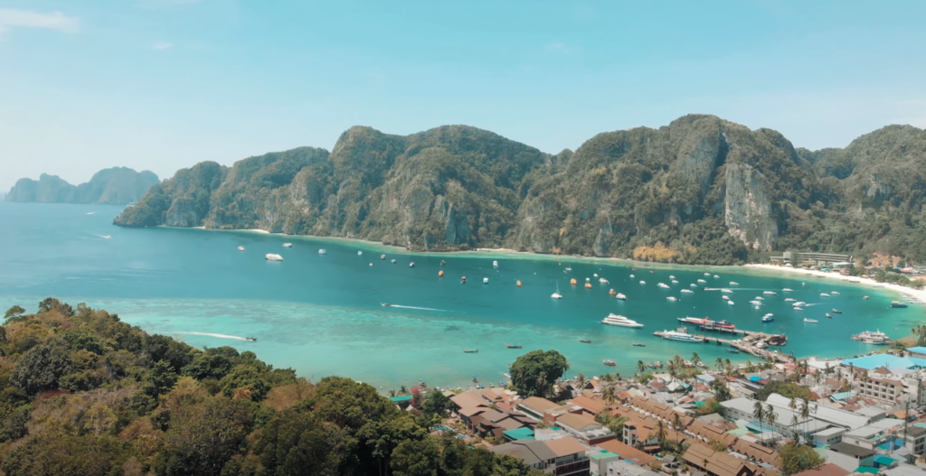 Vue panoramique depuis le pont d'un ferry en route vers Koh Phi Phi, avec une mer turquoise et des îles en arrière-plan.